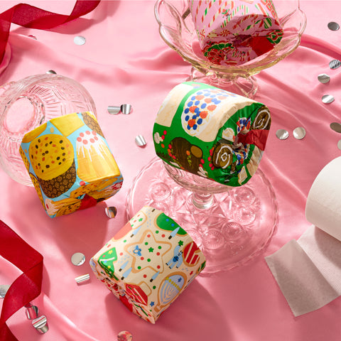 Stacks of colourful 'Who Gives a Crap' Sweet Limited Edition toilet paper rolls arranged on top a table.